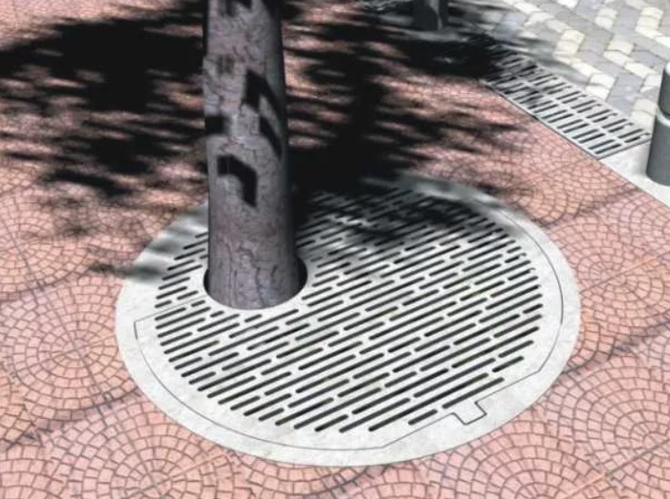 Cazoleta circular de acero galvanizado calada alrededor del tronco de un árbol, en una vereda de baldosas
